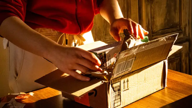 Hands opening a delivered parcel in warm light