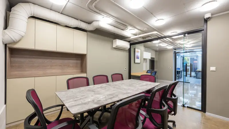 A boardroom with a marble table and glass walls